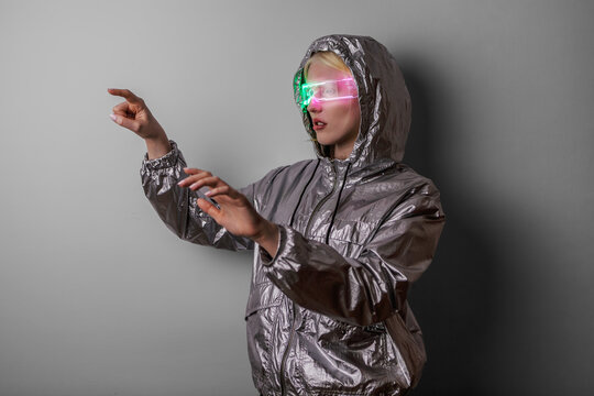Futuristic Woman Wearing Neon AR Glasses in Silver Hoodie