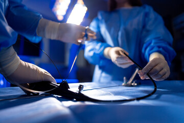 Surgical team readies tools. Medical professionals in scrubs meticulously prepare surgical instruments in a bright operating room.