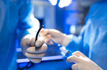 Surgical team operates precisely. Surgeons in blue scrubs diligently work together on a medical...
