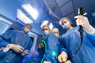 Surgeons doing advanced surgery. Two surgeons operate in a well-lit surgical room using modern...