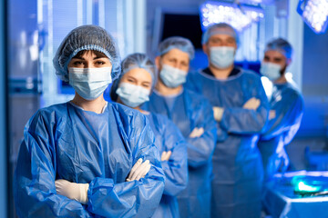 Medical team ready for surgery. A dedicated medical team in blue scrubs and masks is ready for...