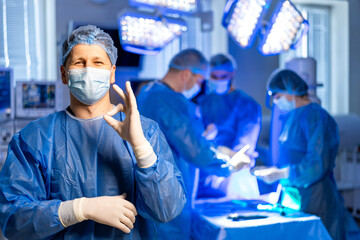 Surgery successfully completed. A medical team in surgical attire collaborates in an operating room while one member shows a thumbs up.