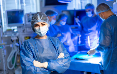 Surgeons working in an operating room. Medical professionals collaborate in a bright OR, focused on...