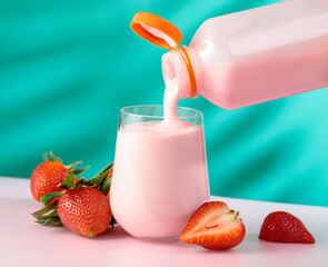 Strawberry milkshake smoothie and fresh berries on a colorful background.