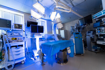High-tech surgical room. A clean surgical room featuring advanced medical equipment illuminated under bright lights, preparing for a procedure.