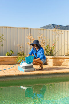 Woman Maintaining Pool with Robot at Home in Australia