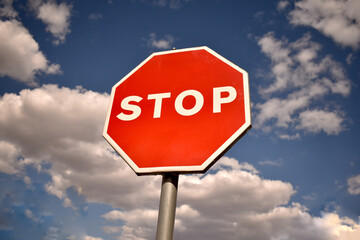 Red stop sign with blue sky background. Road safety and traffic regulation concept.

