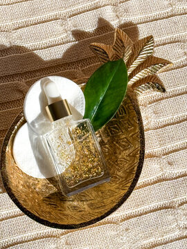 Golden skincare bottle on decorative pineapple shaped tray
