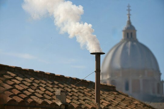 White smoke rises from the chapel chimney, indicating the successful election of a new pope during the papal conclave.
