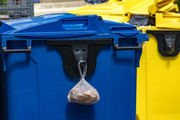 Dry bread in a plastic bag thrown in the trash, hanging on a trash can,