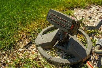 Automatic water sprayer through a hose. Watering the grass in the garden. Summer season 2025