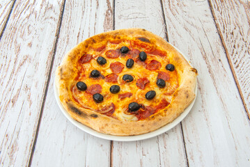 A delicious thin-crust pizza with black olives, spicy pepperoni slices, onions, and lots of cheese and tomato