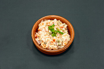 A tapa of Russian salad served in a terracotta container