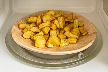 A large plate of chips to prepare patatas bravas in a microwave