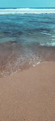 Calming ocean waves gently washing onto a pristine sandy shore