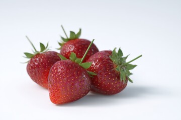 Four ripe strawberries on a white background.  Fresh and juicy!