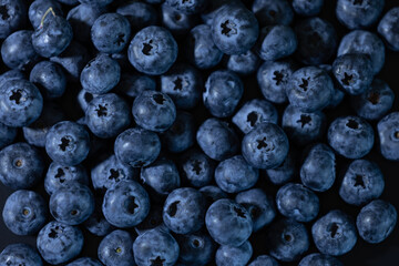 Close-up of fresh blueberries with a dark background.