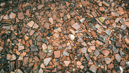 Cracked terracotta tiles create a weathered and textured ground surface