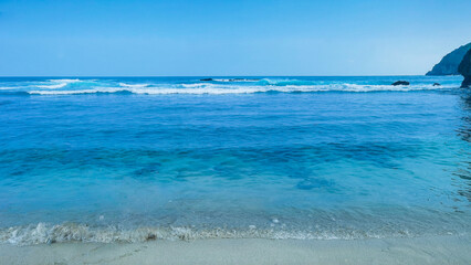 Crystal azure waves softly crashing on sandy shores, a serene vista