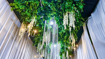 Elegant event space adorned with lush greenery and sophisticated lighting decor