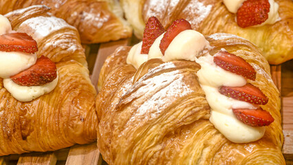 Golden croissants adorned with fresh strawberries and cream indulgence