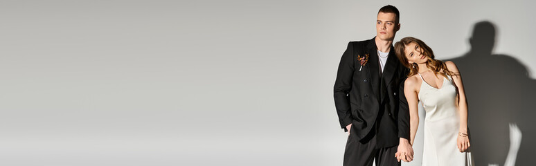 Beautiful couple celebrates love in elegant attire against a minimalist backdrop at sunset