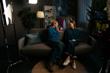 Obraz premium Two Smiling Women Enjoying Casual Conversation on Sofa
