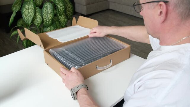 A curious person carefully unboxes a new tech gadget, focusing intently on its product details and elegant packaging.