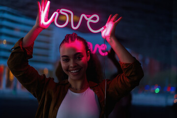 Confident young woman lifts neon 