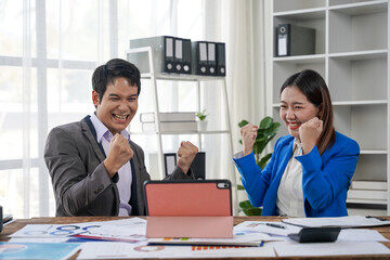 Excited Business Team Celebrating Success at Desk