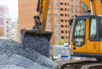 Heavy machinery for construction and landscaping. An excavator on a construction site in close-up....