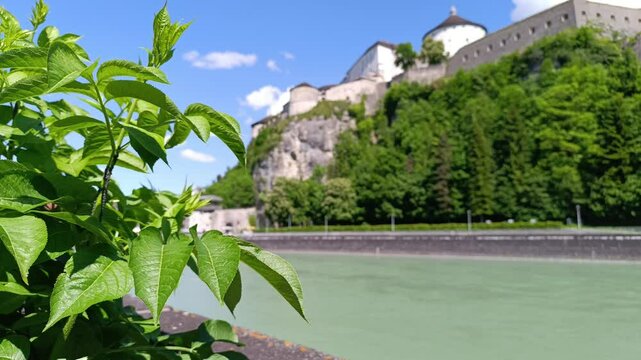 Explore the stunning Kufstein Fortress overlooking the Inn River in Tyrol, Austria on a bright sunny day surrounded by lush greenery
