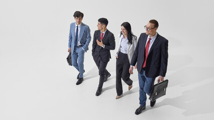 Aerial view of young professionals, dressed formal attire walking and debate against white studio...