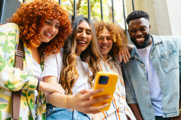 Group of multiethnic friends using smartphone outdoors