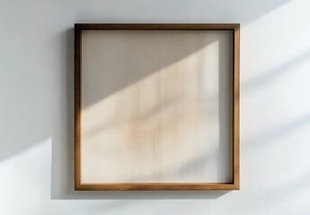 Fototapeta premium A square wooden picture frame hanging on a white wall with empty space.