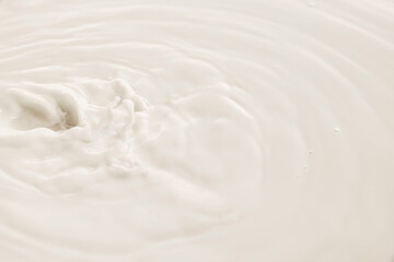 White milk swirls in soft circular motion with textured surface and natural flow. Concept of drink,...