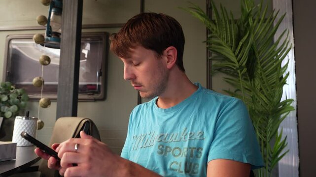 Man using his phone to navigate social media is taken aback by something he finds