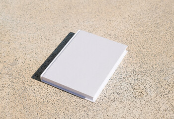 empty book mockup on concrete stone floor or pavement outdoors
