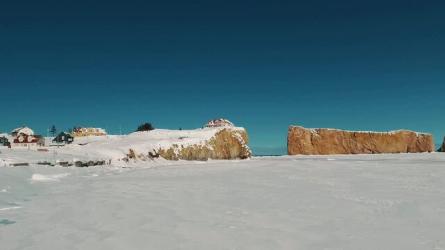 Cinematic view of Perse Rock in the Gaspe Peninsula, captured on a clear winter day