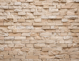 Obraz premium empty backdrop of a wide cream brick wall texture beige old brown brick wall made of concrete or stone abstract wallpaper resembling limestone flooring uneven grid of interior rock home decor d