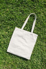 Canvas tote bag lying on green grass outdoor