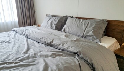 Cozy bedroom with soft gray bedding and natural light in interior