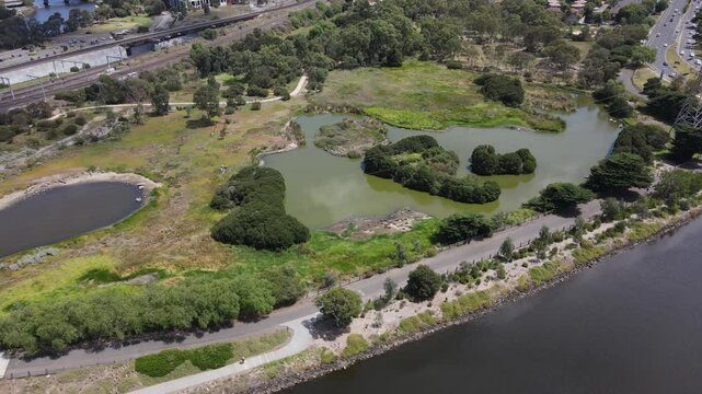 Aerial drone over nature reserve and train line, capturing greenery and birds