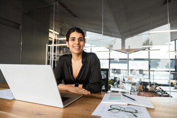 Portrait young it specialist latin hispanic business lady working online on laptop pc sitting at...