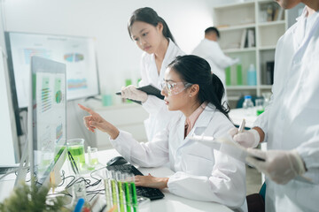 Scientists analyzing data results on laboratory computer monitors, focusing on research,...