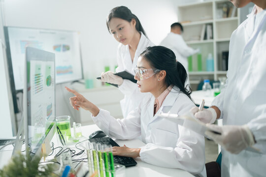 Scientists analyzing data results on laboratory computer monitors, focusing on research, innovation, experiment, teamwork, and biotechnology in modern lab environments for scientific development
