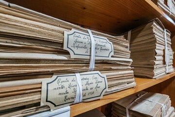 Close-up of Bundled Historic Documents and Registers with handwritten labels in the Archive of...