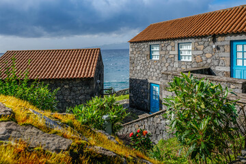Traditional Stone House with Blue Trim in Faja dos Vimes, Sao Jorge, Azores, Portugal. Rural Island Architecture. Quaint traditional Captures the unique island architecture © ikuday