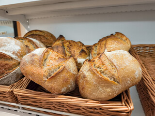 Freshly baked sourdough bread displayed in wicker basket in prague bakery