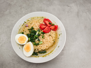 Instant noodles with boiled eggs, tomatoes and spring onions in prague copy space